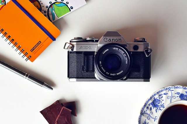 camera, pen, notebook,and cup of tea