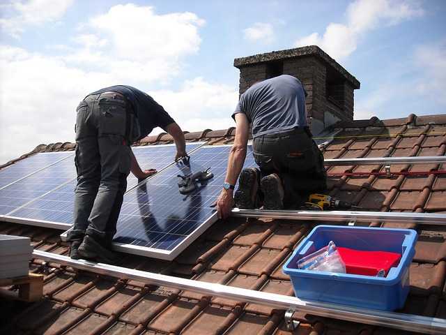 Two workers installing solar on roof